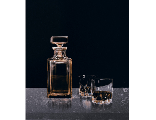 An illustration of a bottle of whiskey beside two tumblers