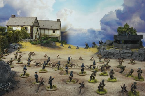 A photo of fully painted miniature figures and terrain depicting WW2 German soldiers advancing