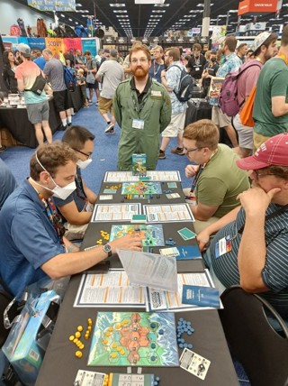 A photo from the Gen Con 2023 convention, showing a member of the Osprey Games team demo-ing General Orders: World War II