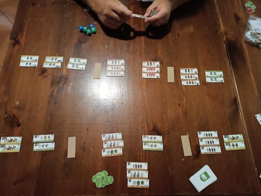 A close-up photo of the prototype set up for a game on a table, with temporary art and design standing in for the various components