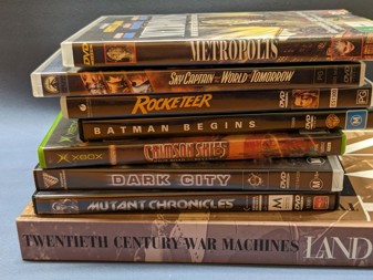 A stack of DVDs, video games and books: Metropolis, Sky Captain and the World of Tomorrow, Rocketeer, Crimson Skies, Dark City, Mutant Chronicles, Twentieth Century War Machines