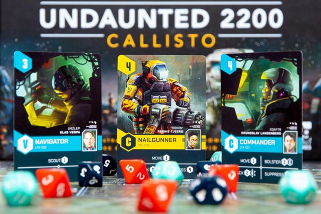 A photo of three cards from Callisto side by side, with art showing various futuristic soldiers, with polyhedral dice in different colours in front of them