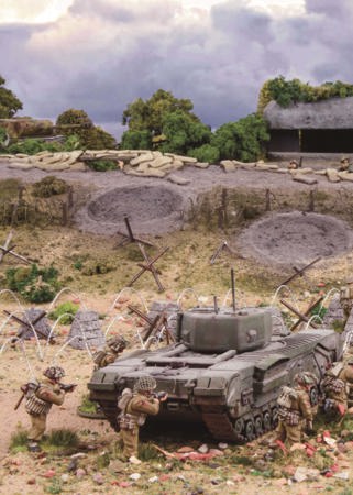 A photo of fully painted miniature figures and terrain depicting a unit of WW2 soldiers moving towards an entrenched bunker behind a tank, with barbed wire and tank traps between them