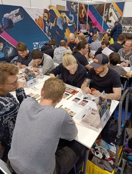 A photo of members of the public playing demos of Battalion: War of the Ancients on the Osprey Games stand at the Essen SPIEL convention 2024