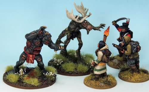 A photo of fully painted miniatures from North Star Military Figures, depicting Baxbaxwalanuksiwe and a wendigo facing off against a trio of adventurers