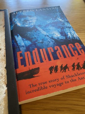 A photo of the book Endurance: The true story of Shackleton's incredible voyage to the Antarctic, with a cover depicting a team of men pulling a ship across ice