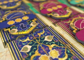 A close-up of the game board showing the graduation tokens, decorated with turbans