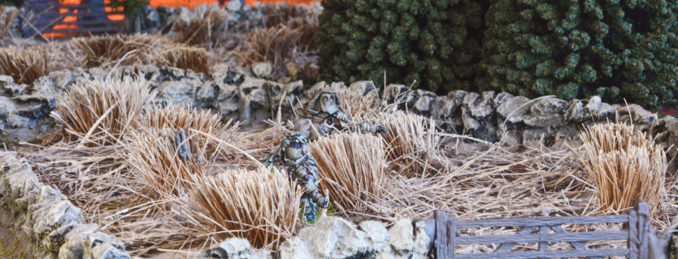 A photo of fully painted miniature figures and terrain for the WW2 wargame Bolt Action: snipers taking cover in long grass