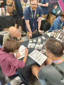 A photo of a member of the Osprey Games team demo-ing War Story to members of the public at Gen Con 2024