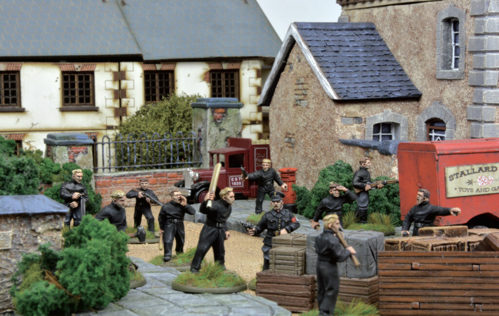 A photo of fully painted miniatures and terrain for WW2 wargaming depicting a unit of fascist volunteers