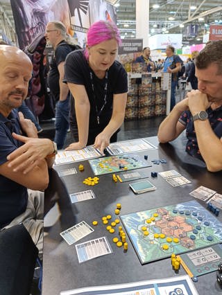 A photo of a member of the Osprey Games team demo-ing General Orders: World War II to the public at SPIEL 2023